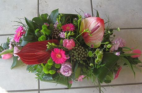 Flower table arrangement made of  anthurium, germini, tulips, santini, freesia and green
